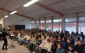 140 collégiens, réunis dans la salle polyvalente du collège Pays Blanc, en train de chanter sous la direction de Cécile Boutry, coordinatrice chant choral du bassin
